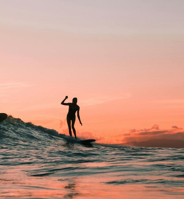 Person feeling energetic and stretching outdoors at sunrise.
